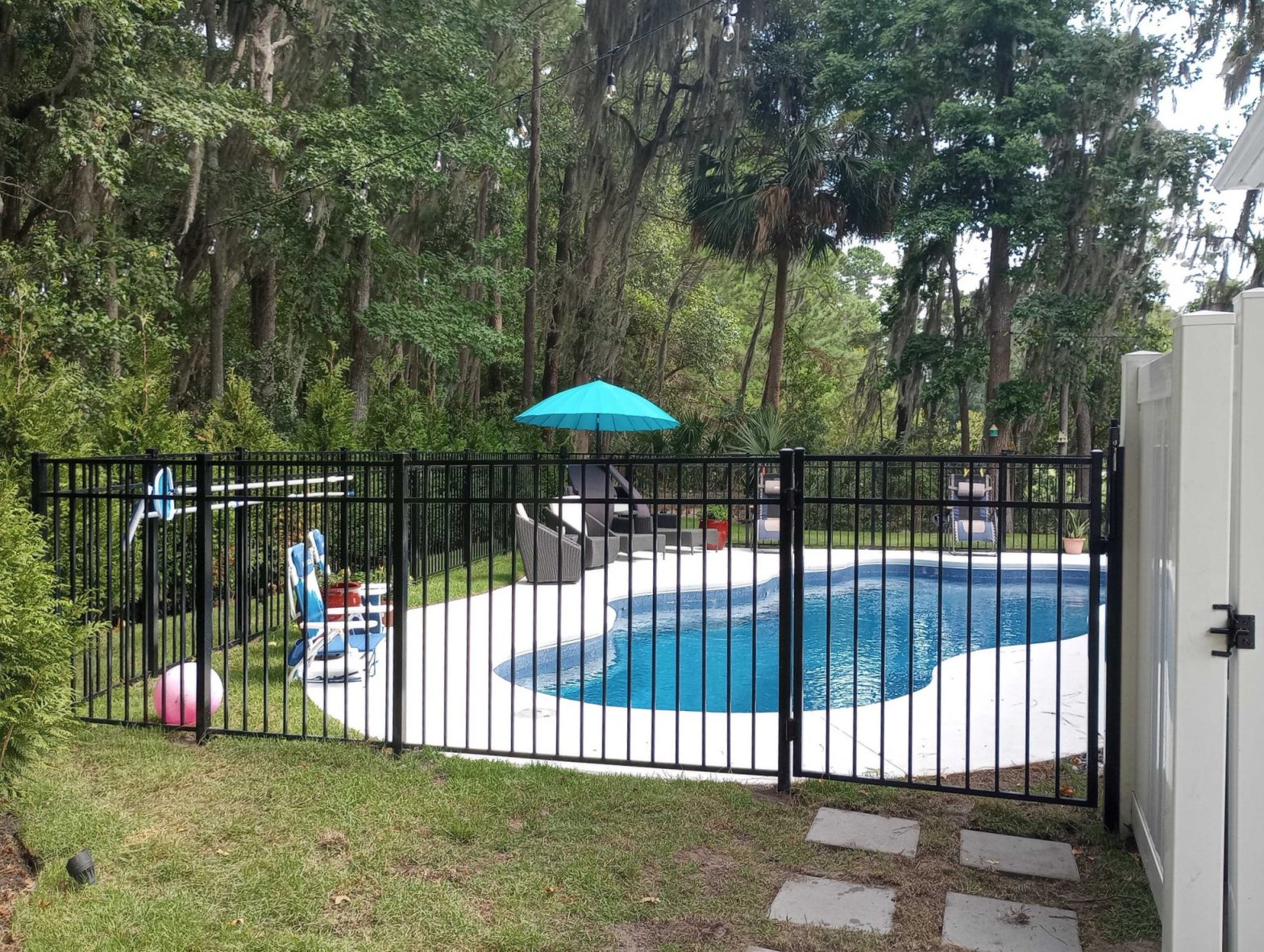 Photo of a black aluminum fence around a pool